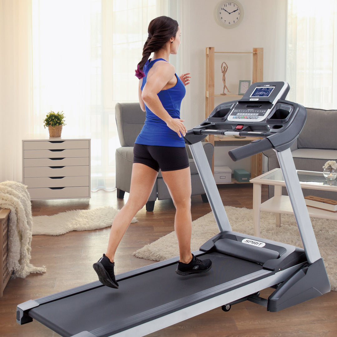 Mujer corriendo en la trotadora Spirit XT285 en el living de su casa